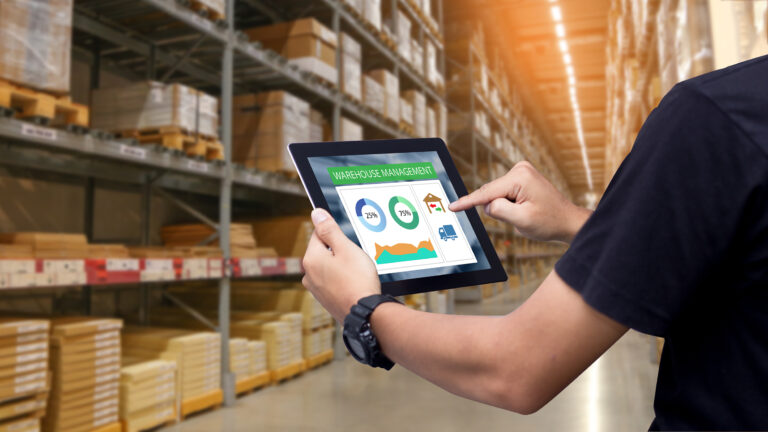 Man holding tablet in front of a warehouse monitoring ingress and purchase rates
